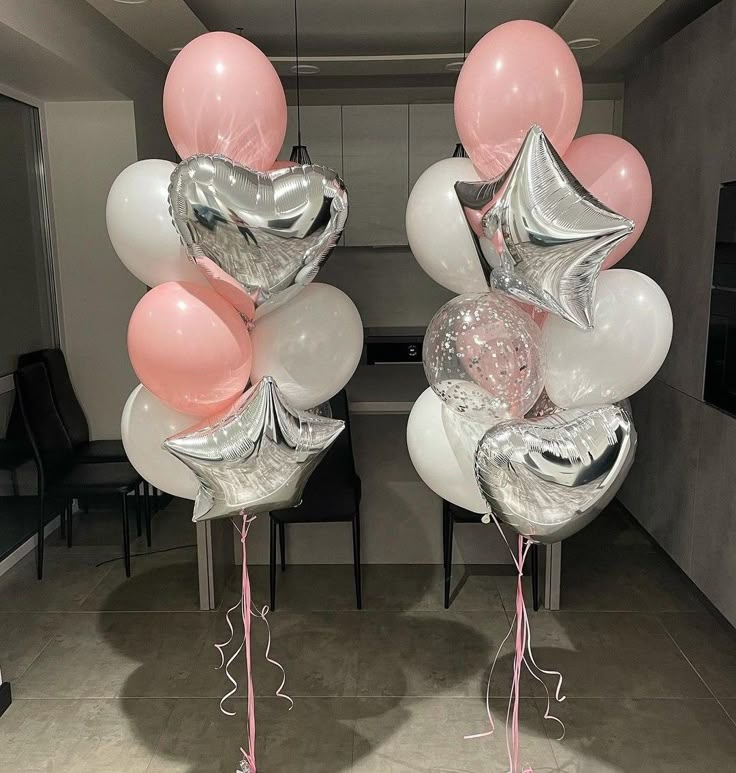 balloons and streamers are arranged in the shape of animals, with pink ribbons on them