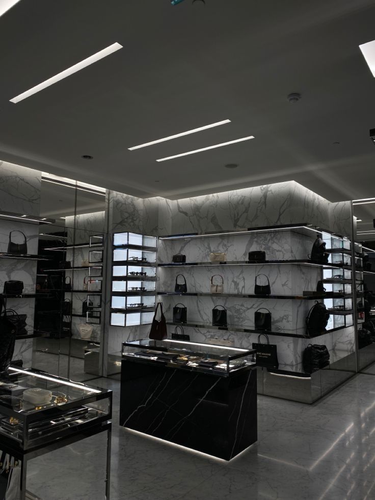 an empty store with marble counter tops and shelves filled with handbags, purses and jewelry