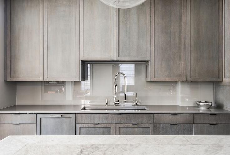 a kitchen with gray cabinets and white marble counter tops is featured in the ad for an appliance company