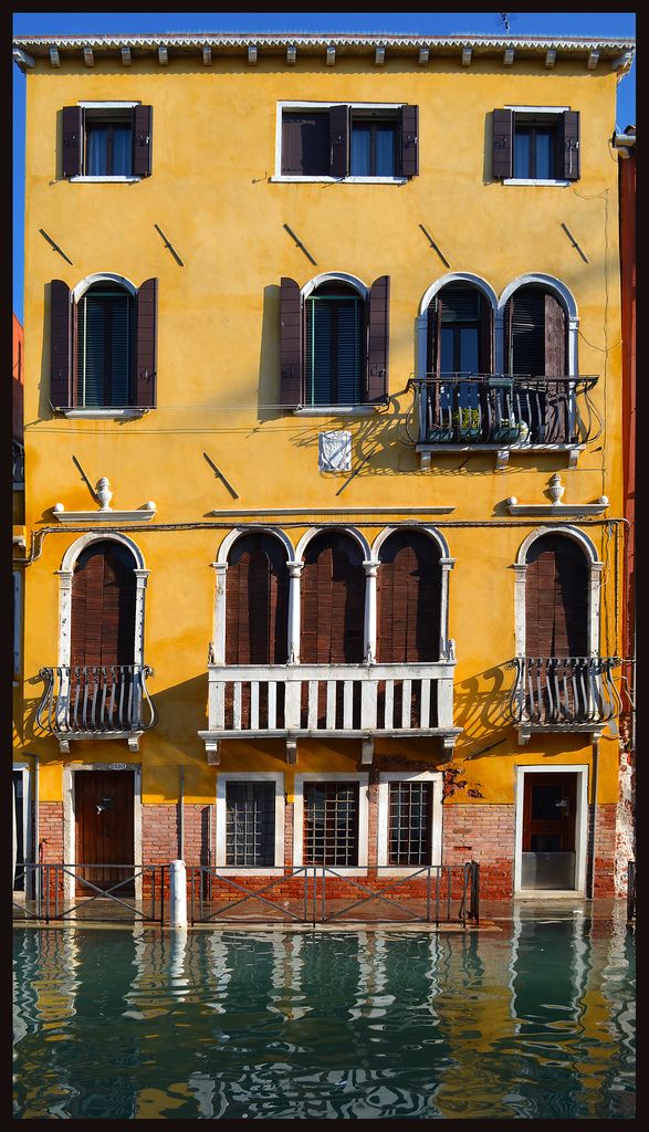 a yellow building with lots of windows and balconies