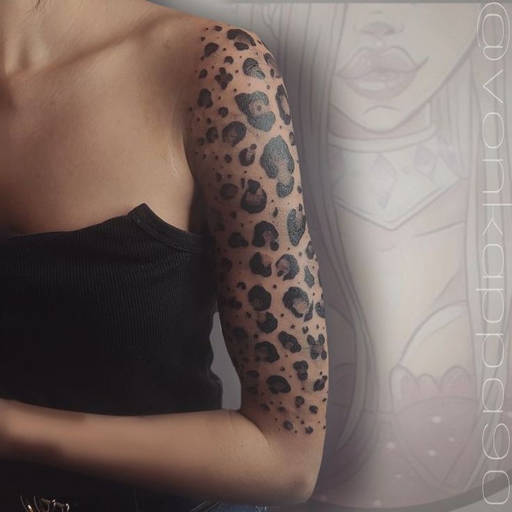 a woman's arm covered in black and grey leopard print tattoo design on her left arm