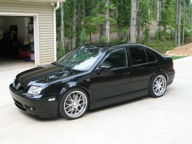 a black car parked in front of a garage