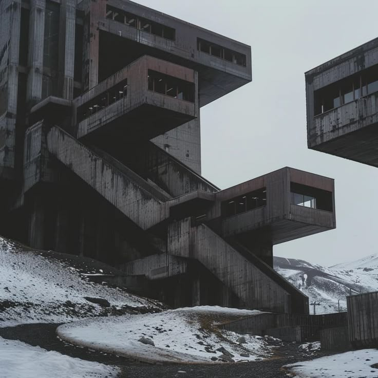 two concrete buildings with balconies on top of them in the middle of snow covered ground