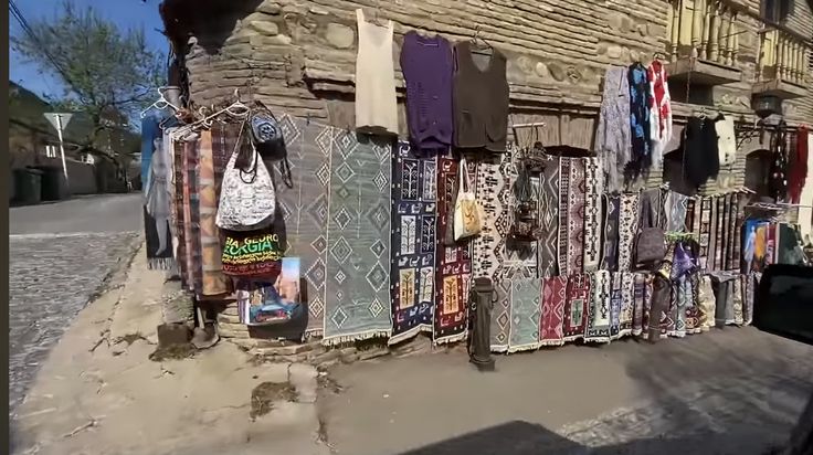 there are many different items hanging on the clothes line in front of an old building