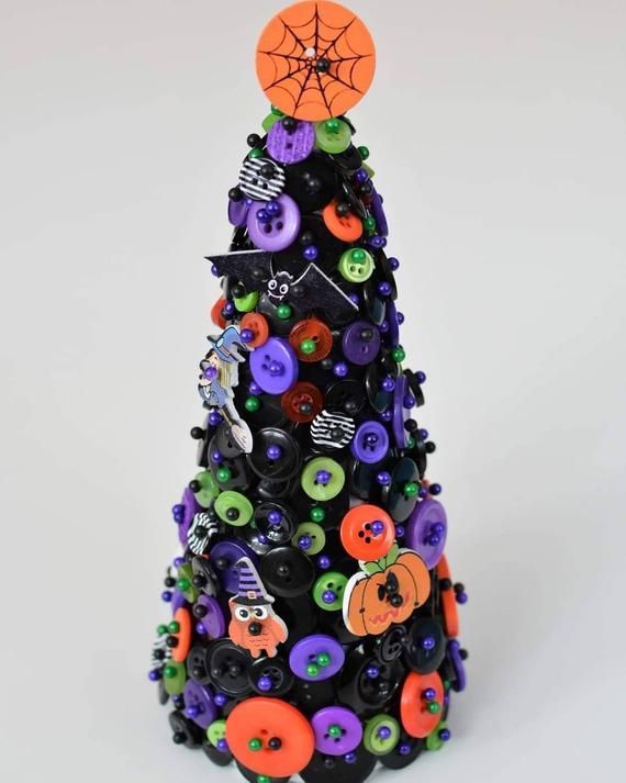 a small christmas tree made out of buttons and other items is shown on a white background