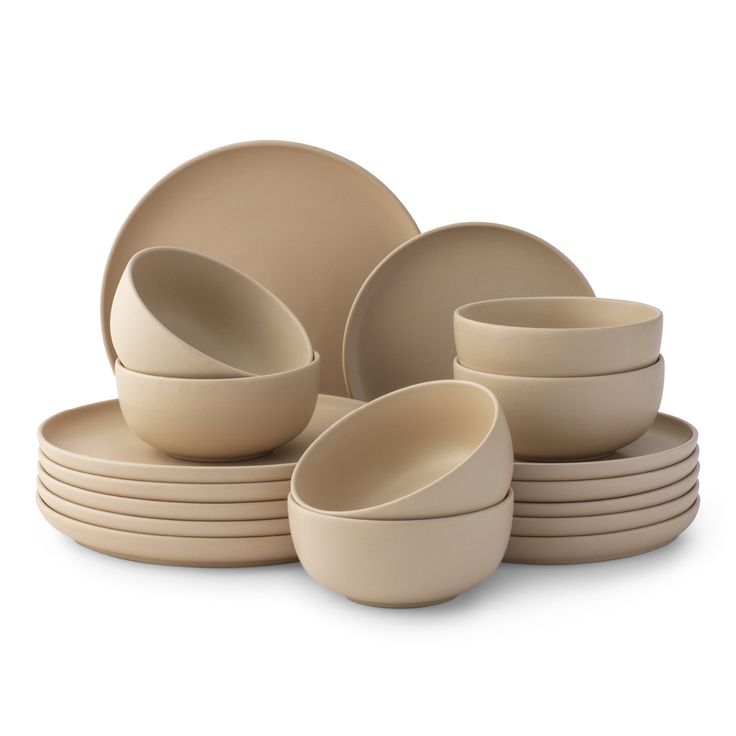 the beige dishes are stacked on top of each other and ready to be placed together