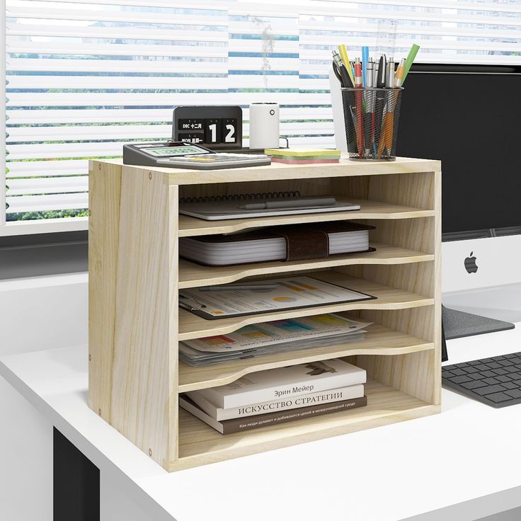 an office desk with a computer and books on it