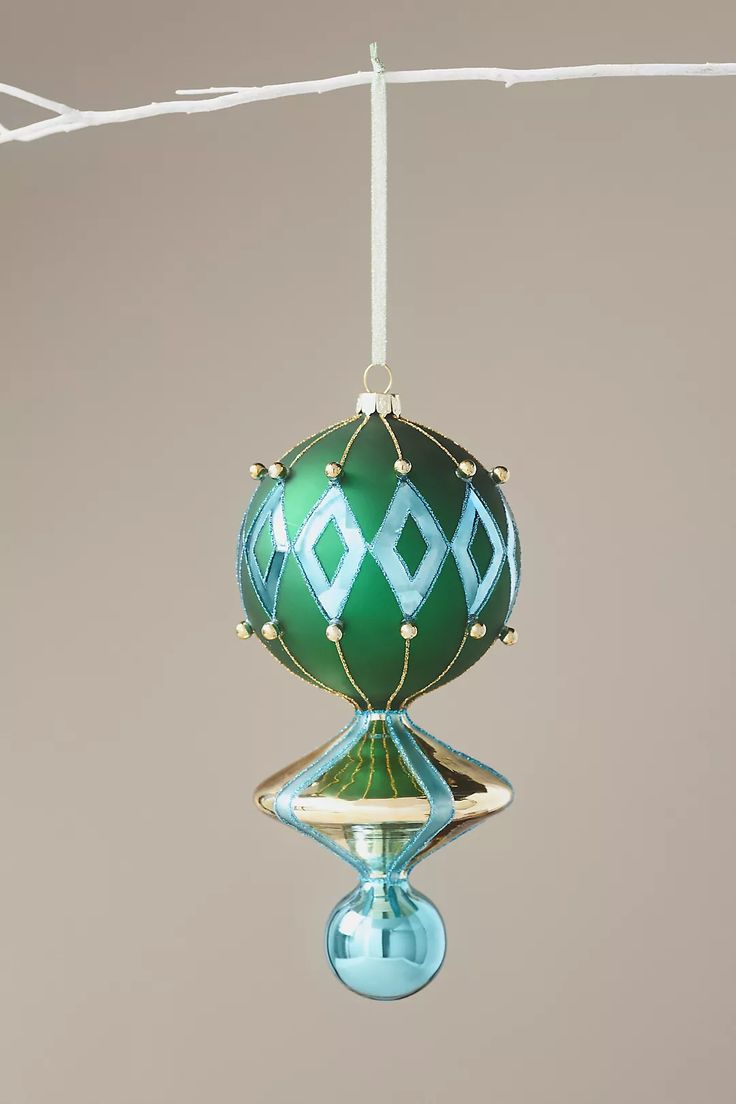 a green ornament hanging from a white string