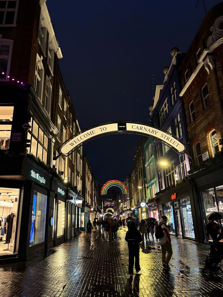 people are walking down the street at night