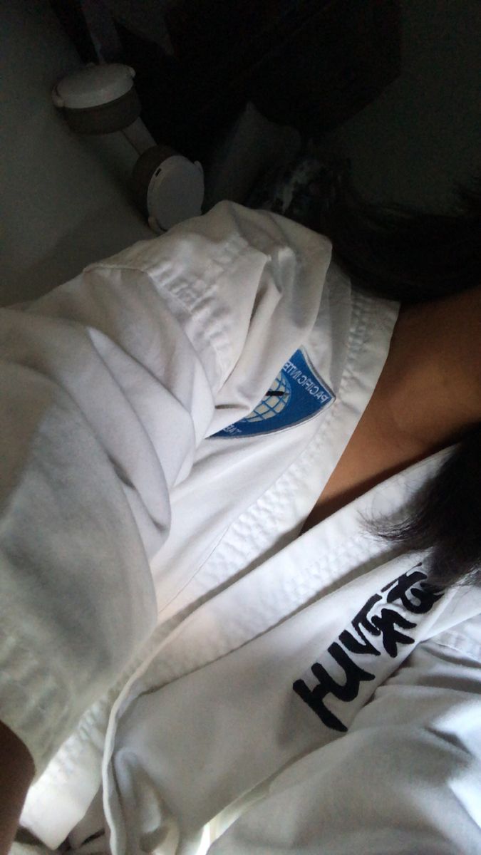 a woman laying on top of a bed wearing a white shirt with the word hunk written on it