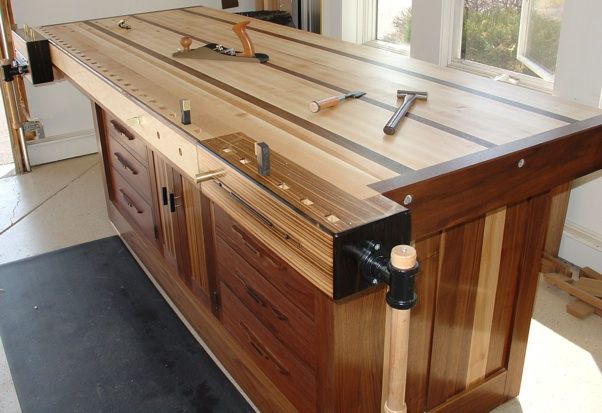 a kitchen island made out of wood with tools on the top and drawers in front