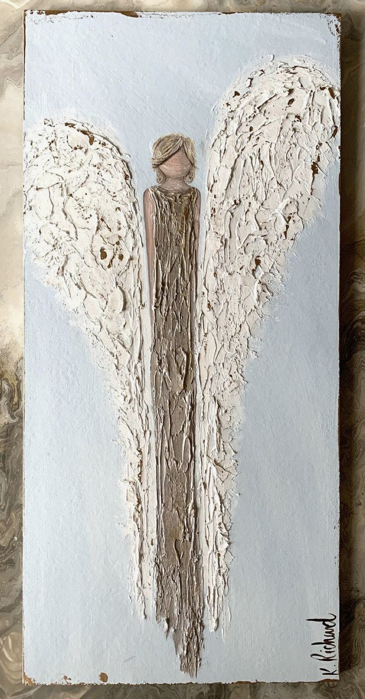 an angel painted on a piece of wood with white paint and shabby wings in the center