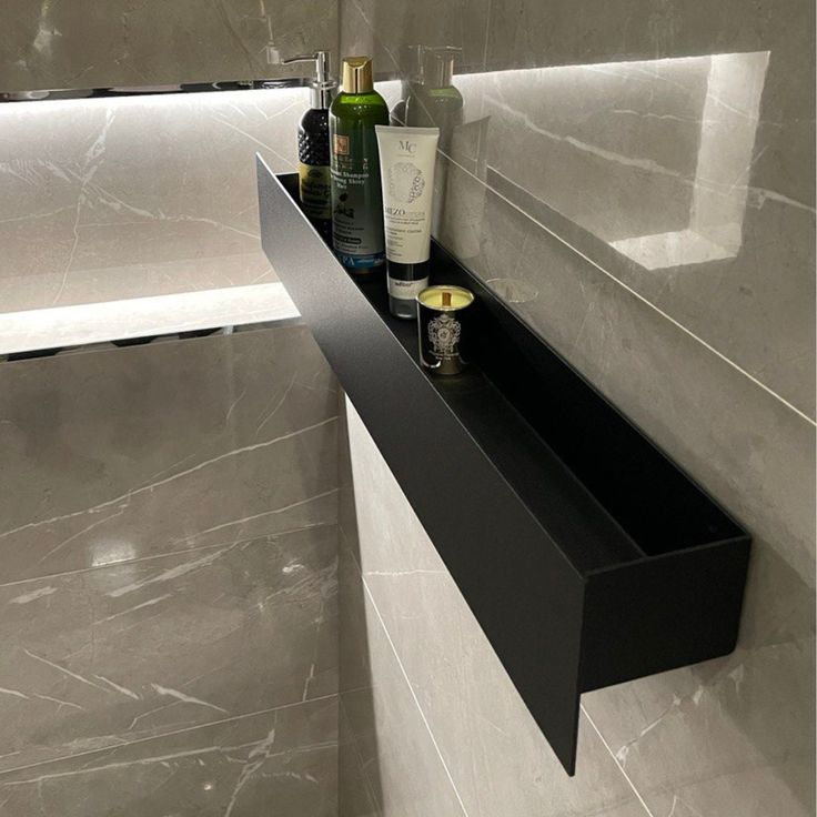 there is a shelf in the bathroom with bottles on it