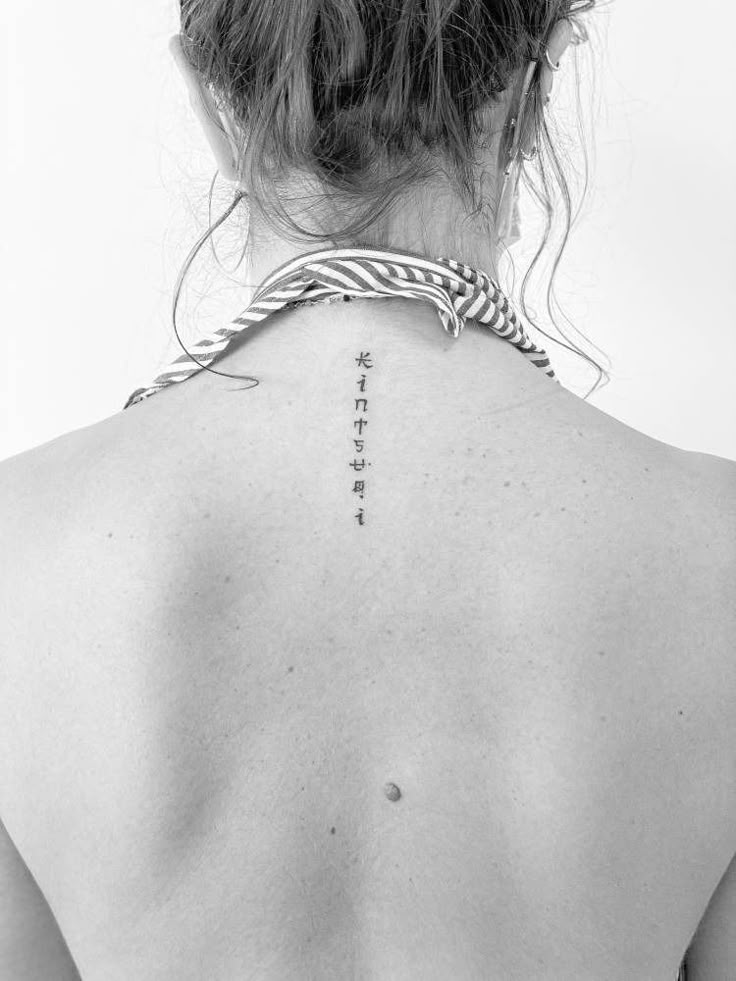 the back of a woman's neck with chinese writing on it