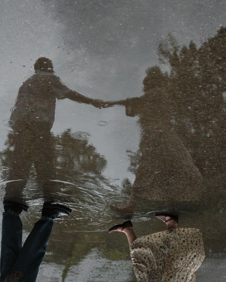 two people standing in the water holding hands