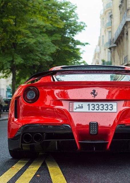 a red sports car is parked on the street