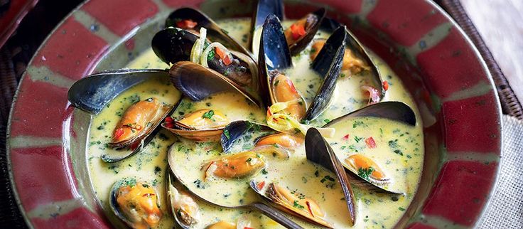 a bowl filled with clams and sauce on top of a table