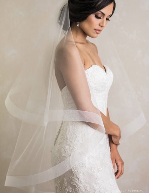 a woman in a wedding dress with a veil on her head