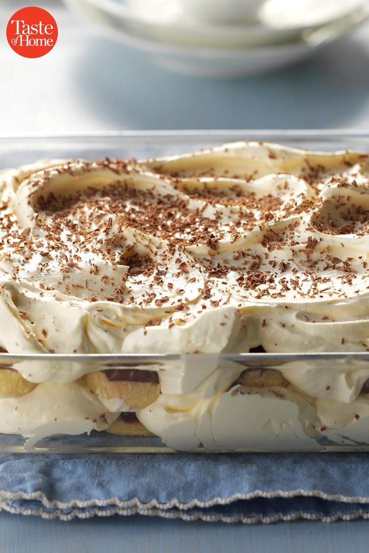 a cake with white frosting and cinnamon sprinkles on top in a glass dish