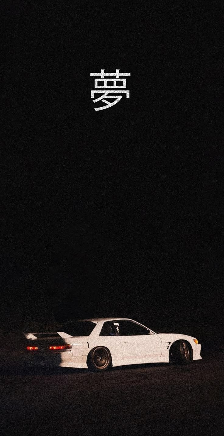 a white car is parked in the dark