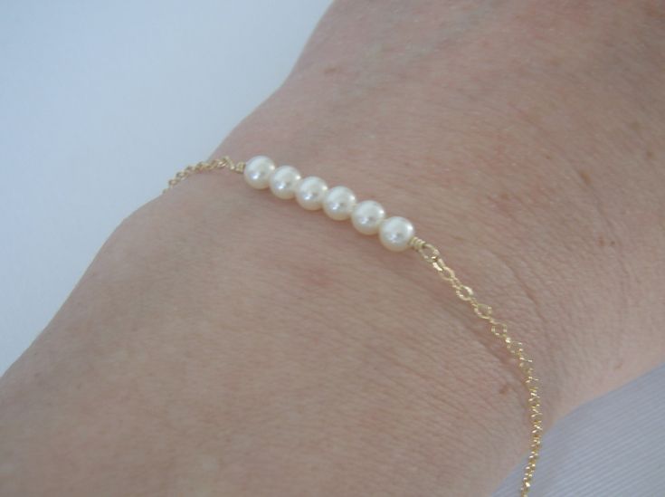 This dainty bracelet is made with six 4mm Swarovski creamy white pearls attached to a sturdy 14k yellow gold filled chain. Closes with a spring clasp. ~ALL metal is 14k yellow gold filled (NOT Plated) and will last a lifetime. ~Choose a length from the menu or add a note with the length you need ~High Quality chain & findings ~Packaged in a box tied with ribbon FREE SHIPPING Good Jewelry, Gold Pearl Bracelet, Gold Pearl Jewelry, Cheap Bracelets, Michigan City, Dainty Bracelet, Dainty Bracelets, Gold Filled Chain, Gold Pearl