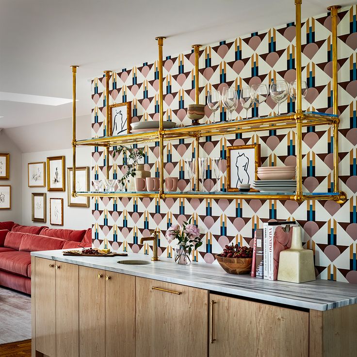 a living room filled with furniture next to a wall covered in pictures and framed art