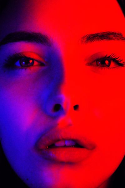 a woman's face with red and blue lighting