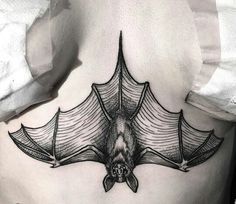 a black and white photo of a bat tattoo