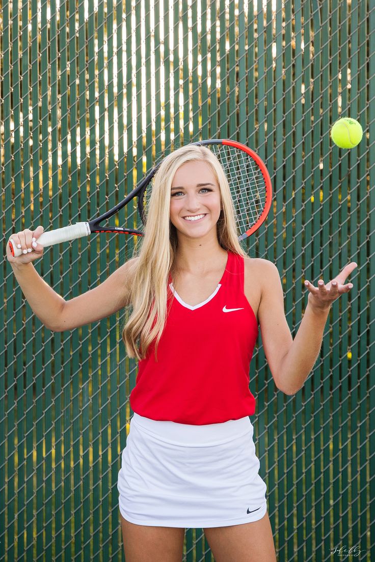 a young woman holding a tennis racquet on top of a tennis ball court