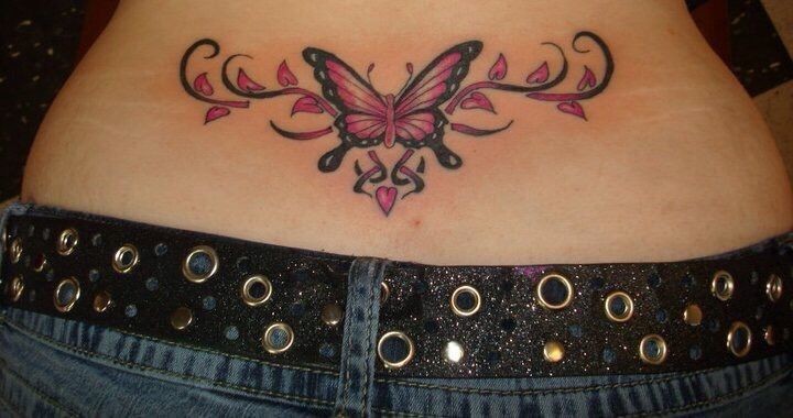 a woman's stomach with a butterfly tattoo on her belly and pink flowers in the center