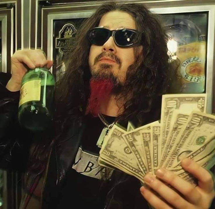 a man with long hair and sunglasses holding money