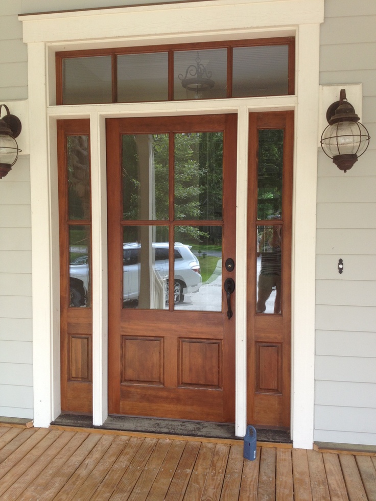 the front door to a house with two lights on it