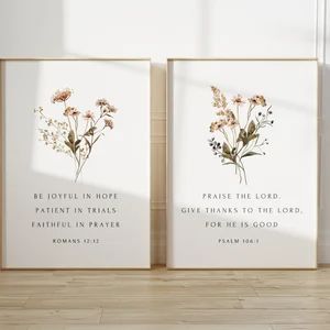 two framed art prints with flowers and bible verses on the wall next to each other