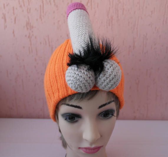 a mannequin head wearing an orange and white knitted hat with black feathers