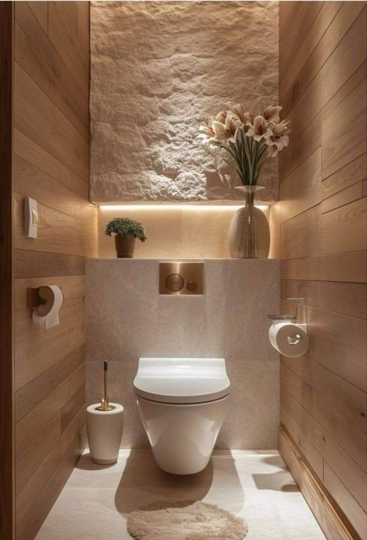 a white toilet sitting inside of a bathroom next to a wooden paneled wall and floor