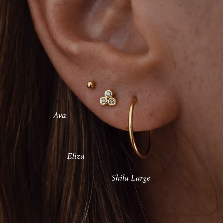 a woman's ear with three different types of piercings