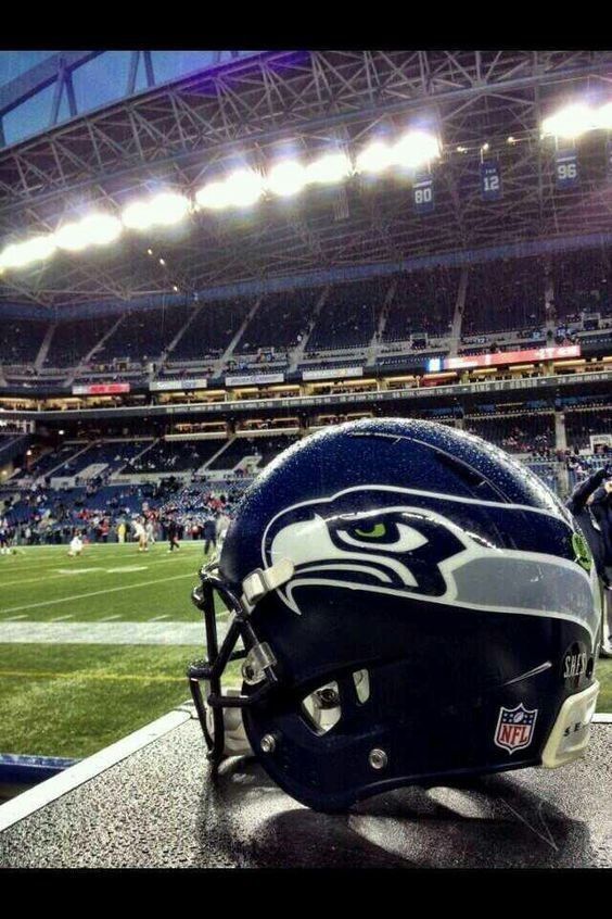 a helmet sitting on top of a table in front of a stadium filled with people