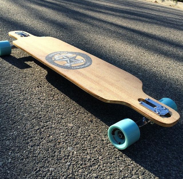 a wooden skateboard with blue wheels on the street