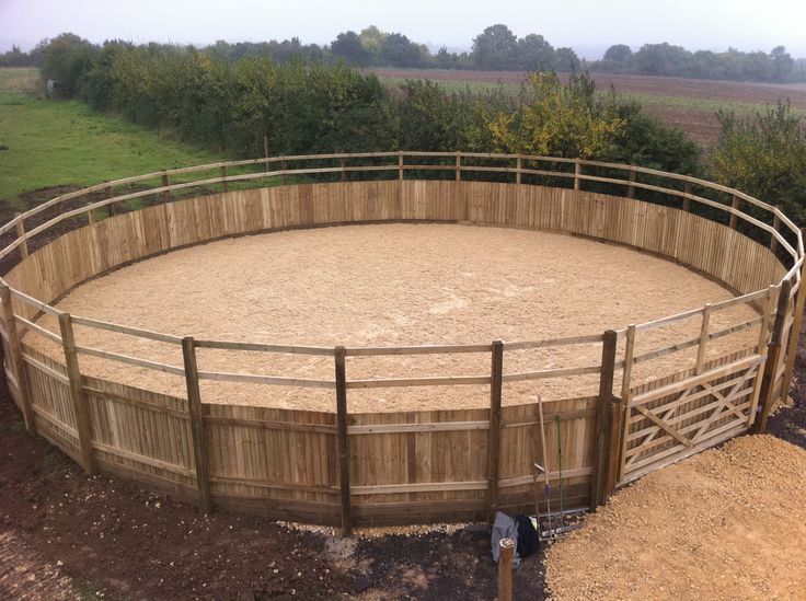 a wooden fenced in area with a large round animal pen