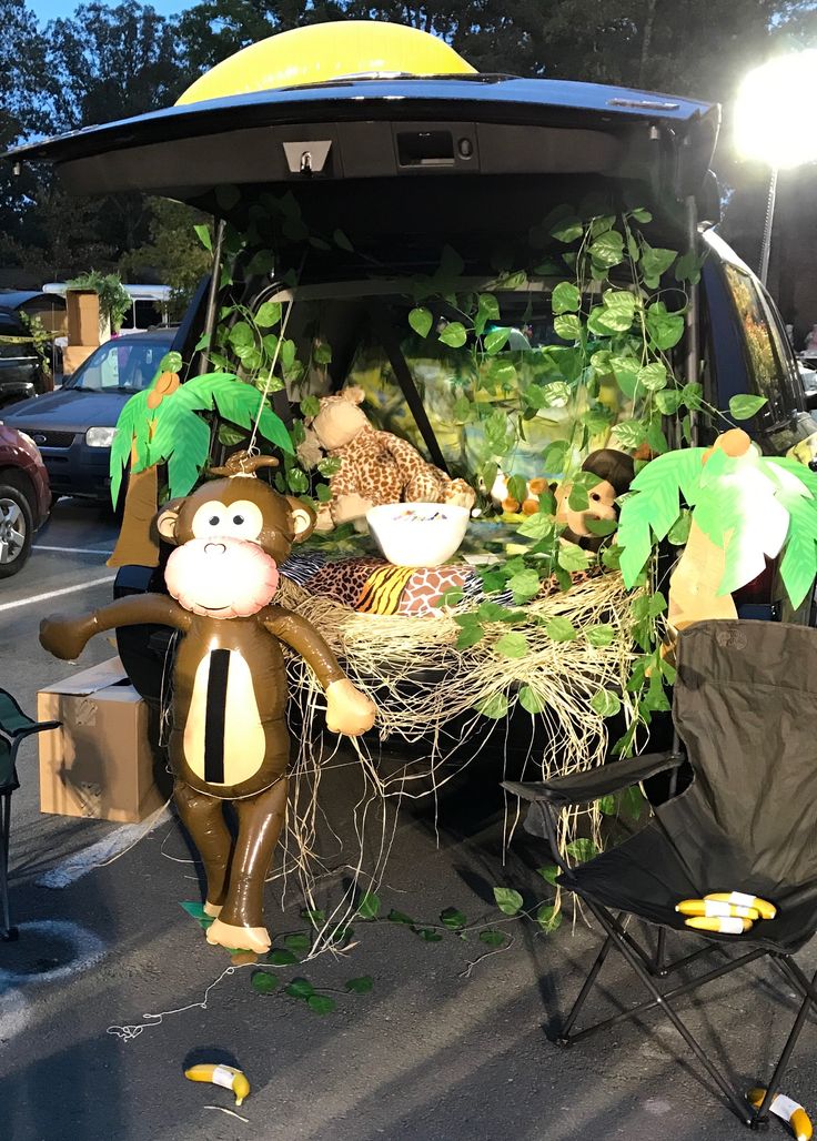 there is a fake monkey sitting in the back of a van with plants growing out of it