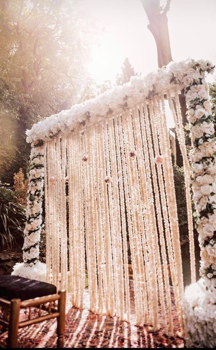 an outdoor ceremony setup with white flowers and beads