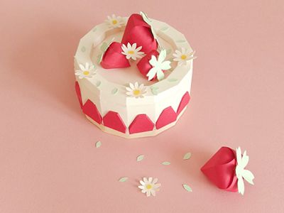 the cake is decorated with daisies and petals on pink surface next to two small flowers