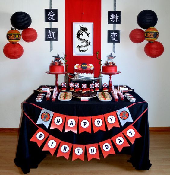 a table topped with lots of desserts and red paper lanterns hanging from the ceiling