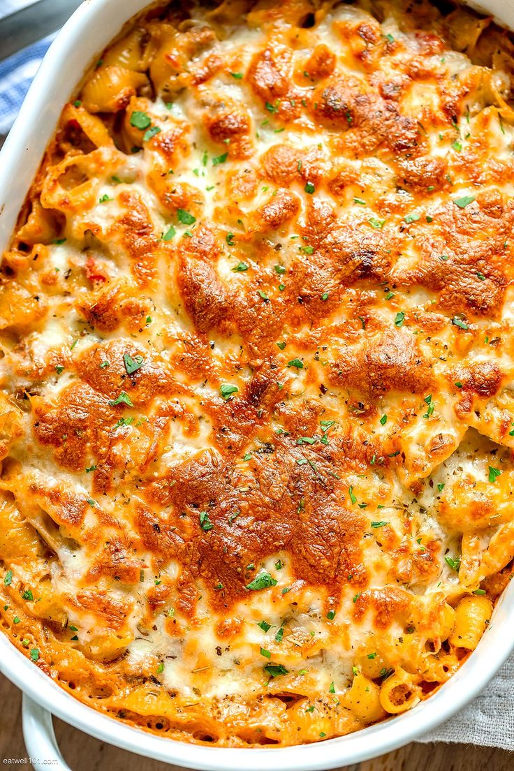 a casserole dish with cheese and parmesan bread in it on a wooden table