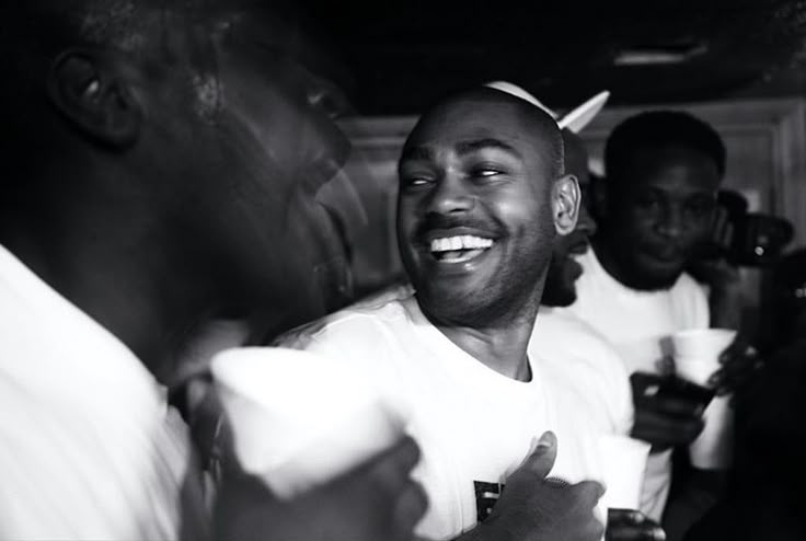 a group of men standing next to each other in a black and white photo smiling