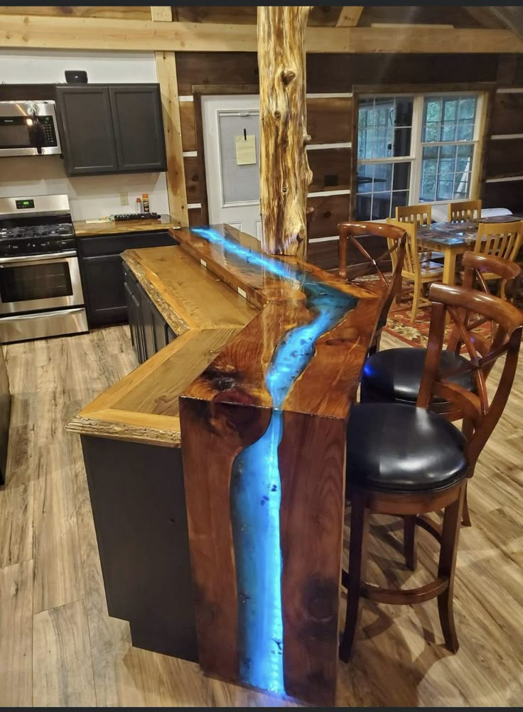 a kitchen island with a blue stream running down the center and two stools at the end