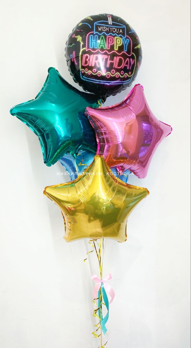 balloons and streamers in the shape of stars are arranged on a white wall for a happy birthday celebration