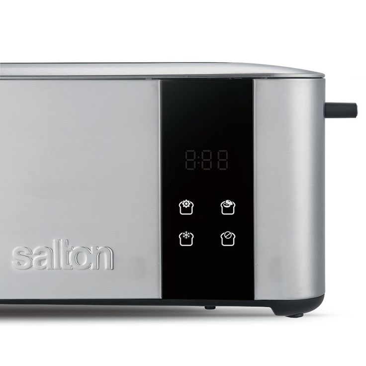 a silver and black toaster sitting on top of a white table next to a clock