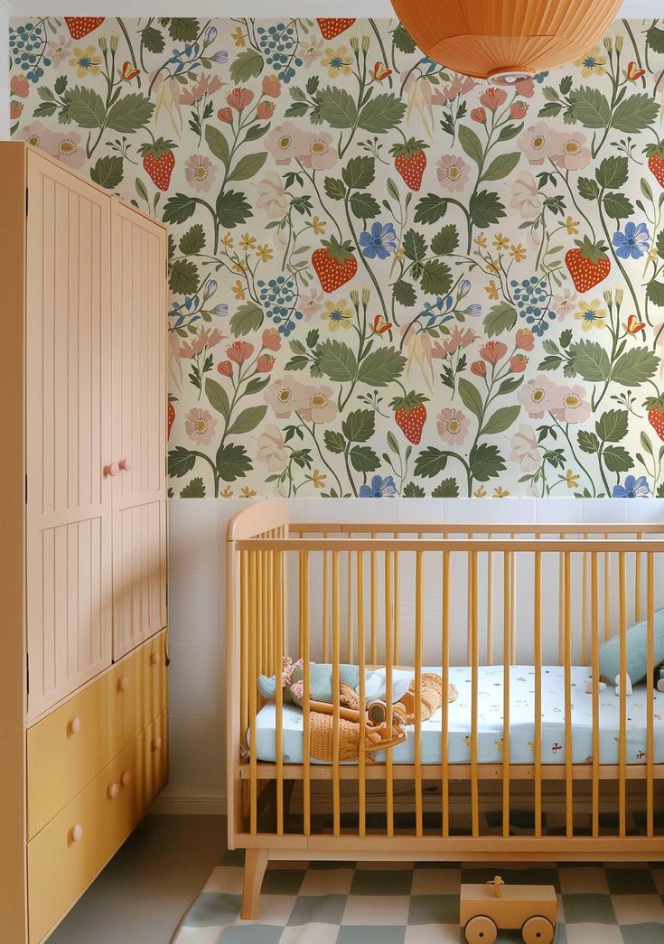 a baby's room with floral wallpaper and wooden crib in the foreground