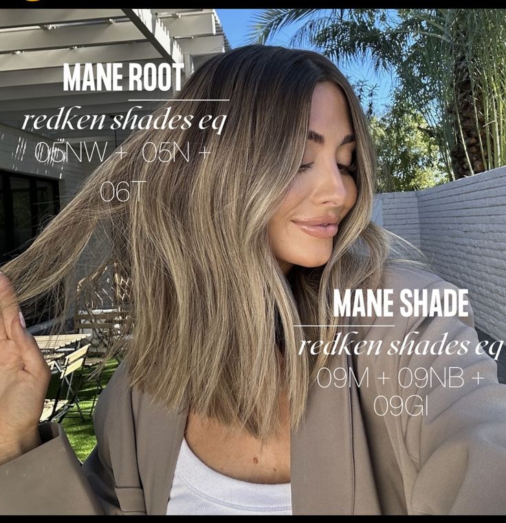 a woman standing in front of a house with her hair blowing in the wind and text that reads mane root redken shades eq